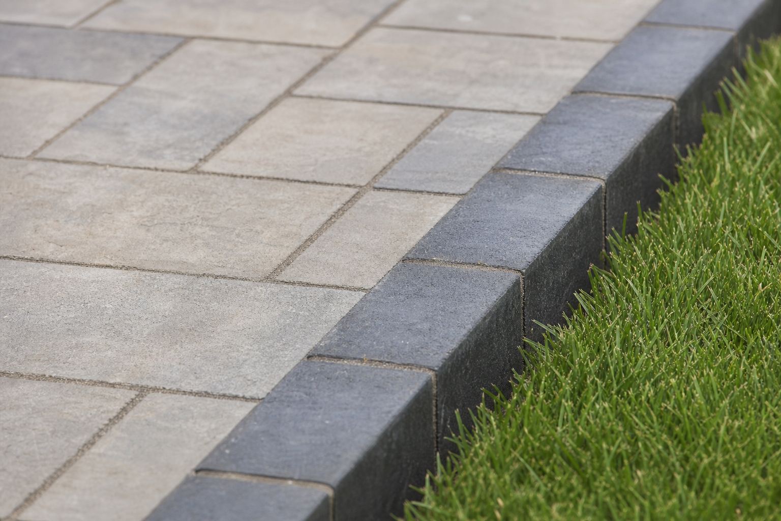 Soldier-course paver edge detail where patio meets lawn — representative design concept