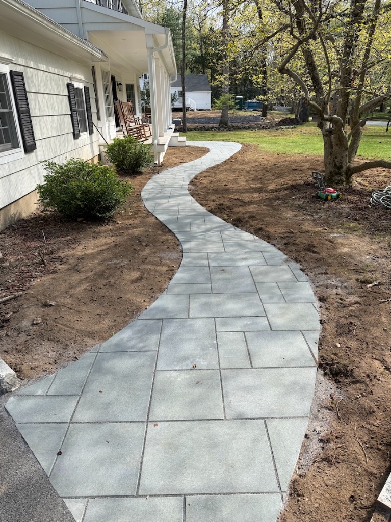 Completed curved paver walkway leading to a white front porch in Bergen County, New Jersey
