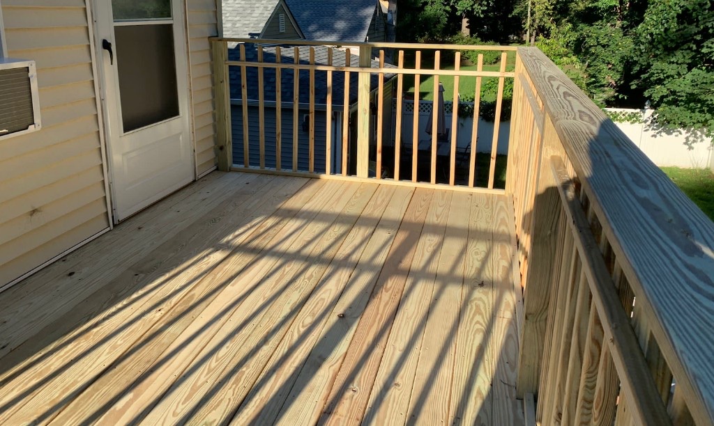 Completed pressure-treated wood deck with wood baluster railing in Northern New Jersey