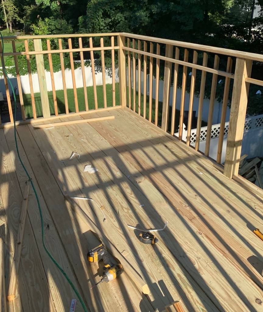 Alternate view of a finished pressure-treated wood deck with wood baluster railing in Northern New Jersey